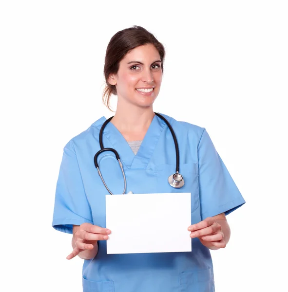 Charmante infirmière tenant une carte blanche — Photo