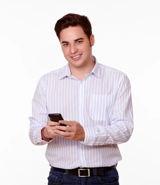 Netter junger Mann lächelt und textet — Stockfoto