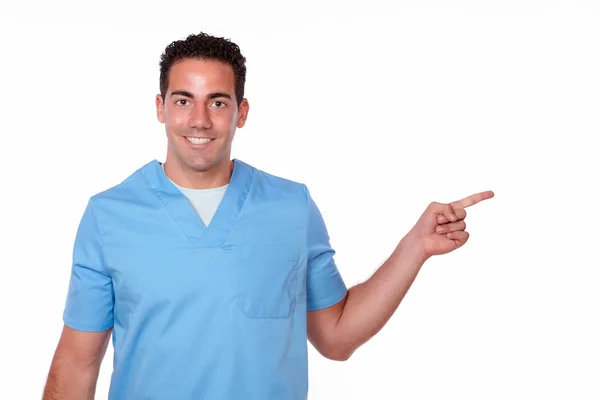 Fashionable nurse guy pointing to his left — Stock Photo, Image