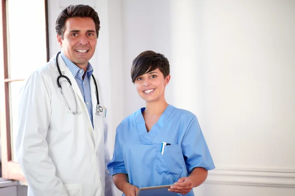 Charmanter männlicher Arzt und hübsche Krankenschwester im Stehen — Stockfoto