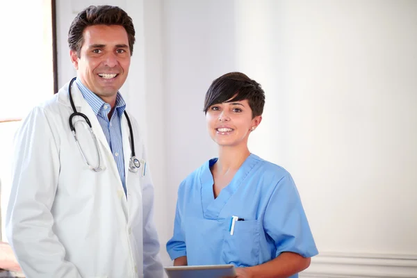 Schöner lateinischer Arzt und schöne Krankenschwester stehen — Stockfoto