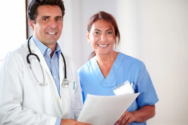 Casal médico sorrindo e olhando para você — Fotografia de Stock