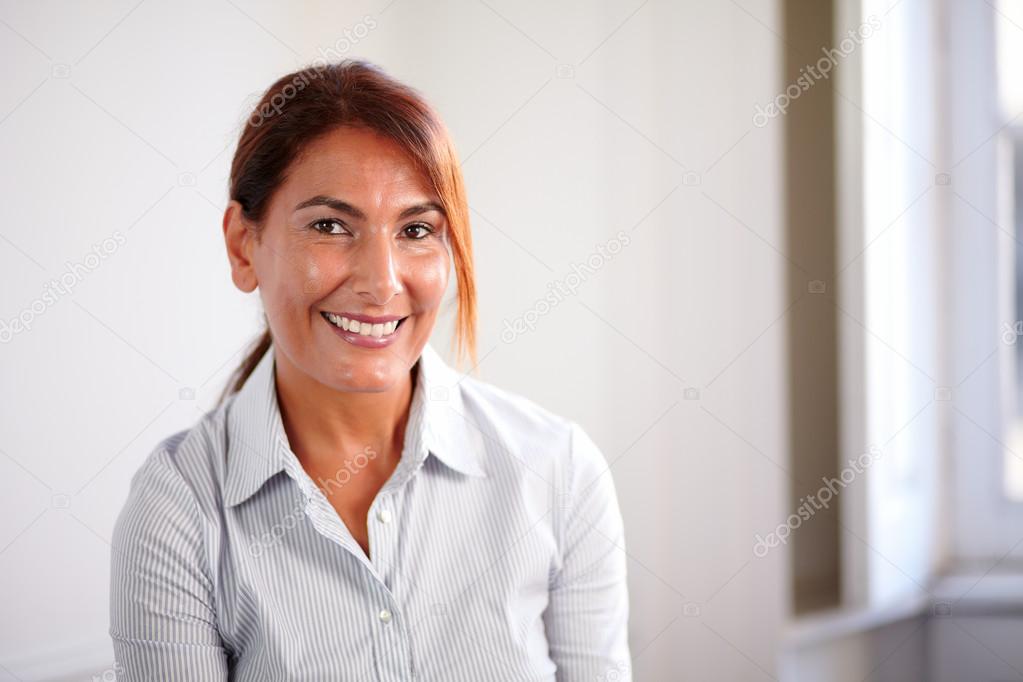 Reflective senior woman smiling at you