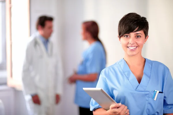 Preciosa enfermera latina de pie uniforme azul — Foto de Stock