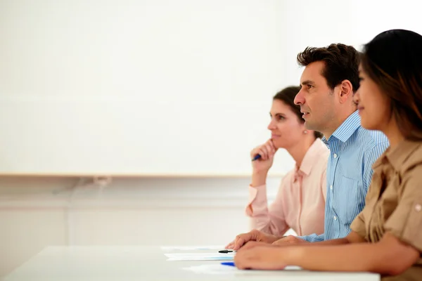 Equipo de hombres y mujeres mirando a la conferencia — Foto de Stock