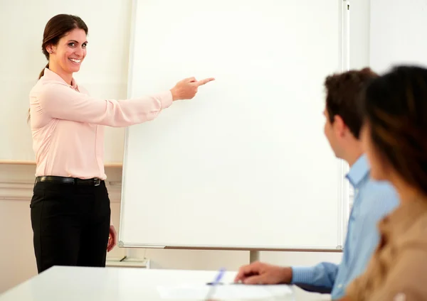 Attractive young woman pointing on whiteboard — Stock Photo, Image