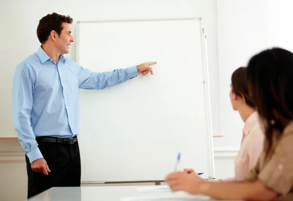 Hombre de negocios adulto guapo apuntando a pizarra blanca — Foto de Stock