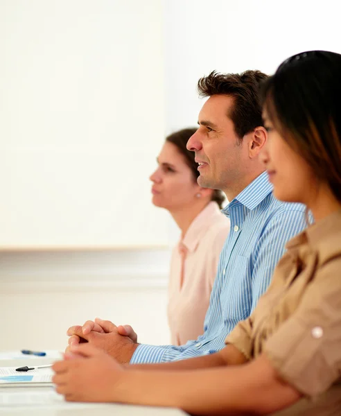 Mannelijke en vrouwelijke collega's luisteren tijdens de conferentie — Stockfoto