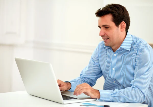Привабливий дорослий бізнесмен використовує свій ноутбук — стокове фото