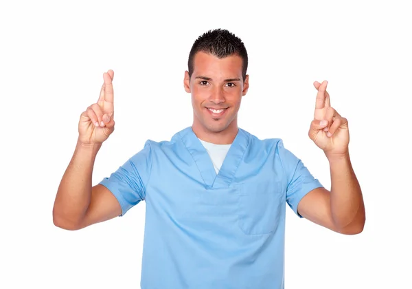 Handsome nurse man crossing his fingers — Stock Photo, Image