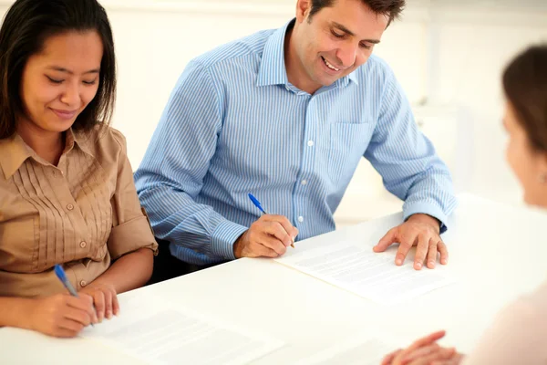 Pareja étnica adulta firmando un contrato — Foto de Stock