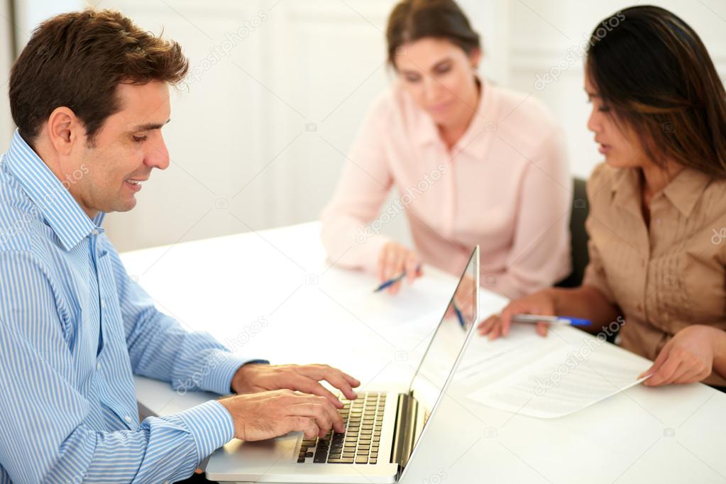 Adult hispanic businessman using his laptop