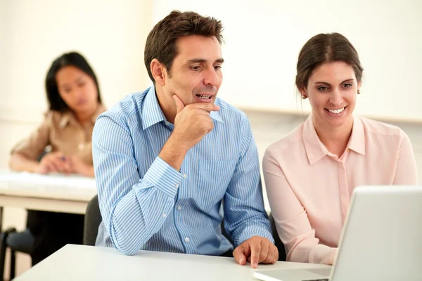Casal executivo trabalhando e olhando no laptop — Fotografia de Stock
