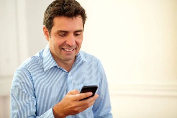 Bonito empresário enviando mensagens com seu celular — Fotografia de Stock