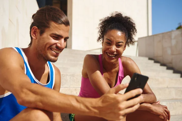 Sorridente Giovane Coppia Navigare Rete Uno Smartphone Mentre Seduti Insieme — Foto Stock