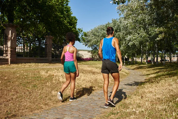观看一对穿着运动服的年轻夫妇在室外散步的场景 — 图库照片