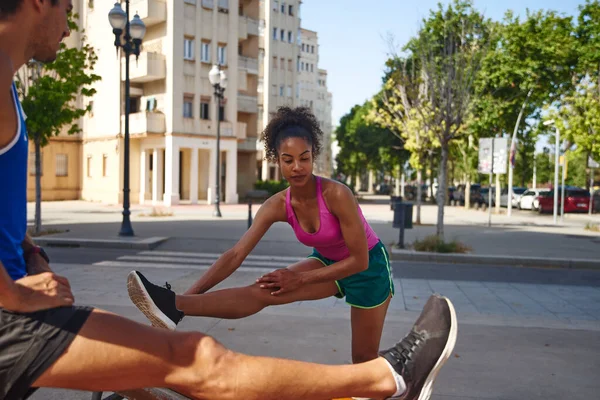 在城市里 这对活跃的夫妇一边活动着双腿 一边一起在户外锻炼 — 图库照片