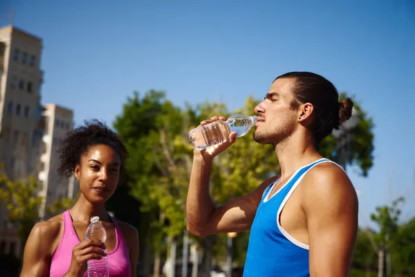 Atletisch Jong Stel Drinkwater Tijdens Het Nemen Van Een Pauze — Stockfoto