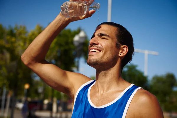 Feliz Joven Deportista Sonriendo Alegremente Mientras Vierte Agua Cara Aire —  Fotos de Stock