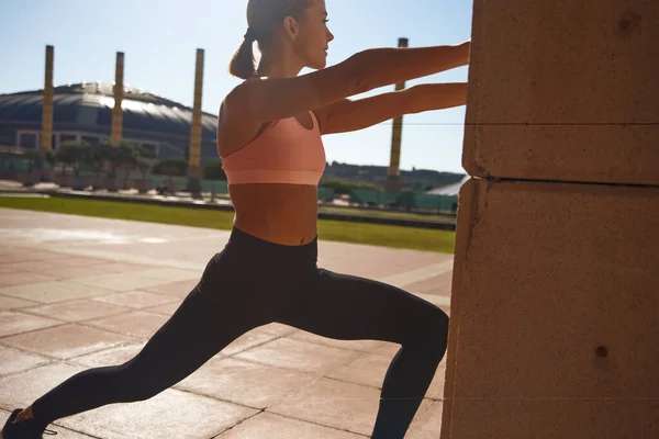 Sportowa Kobieta Ćwiczy Stojąc Rozciągając Się Przeciwko Kolumnie Parku — Zdjęcie stockowe