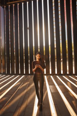 Şık giyinmiş, kaldırımda cep telefonu kullanan güzel bir iş kadını.