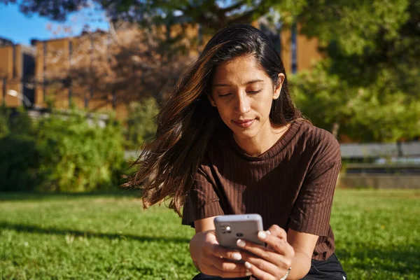 Genç Kadını Güneşli Bir Günde Parkta Oturmuş Mesajlaşıyor — Stok fotoğraf