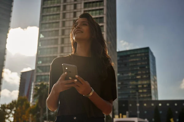 Jovem Mulher Negócios Feliz Rua Usando Telefone Celular Enquanto Olha — Fotografia de Stock