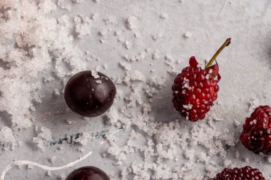 Böğürtlen ve böğürtlen çimento masasında yazın yenecek buzla birlikte.