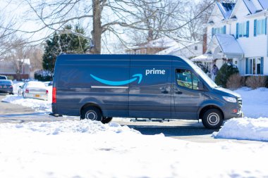 Long Island, New York, Circa 2020 - Amazon Prime nakliye aracı satın alınan malların hızlı bir şekilde ulaşması için kar fırtınası sonrasında yerleşim evlerine paketleri teslim ediyor