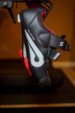 New York - Circa 2022: Peloton fitness brand cycling shoes on back of flagship stationary bike for fitness and exercise clipart