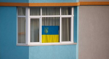flag of Ukraine on the window of the house. High quality photo