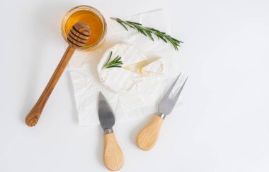 Bal ve biberiye filizli beyaz tabakta yuvarlak brie ya da camembert peyniri