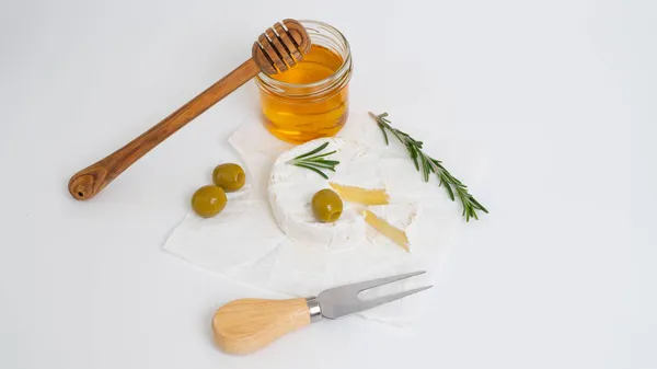 Bal ve biberiye filizli beyaz tabakta yuvarlak brie ya da camembert peyniri