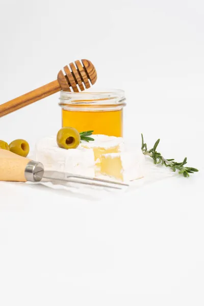Bal ve biberiye filizli beyaz tabakta yuvarlak brie ya da camembert peyniri
