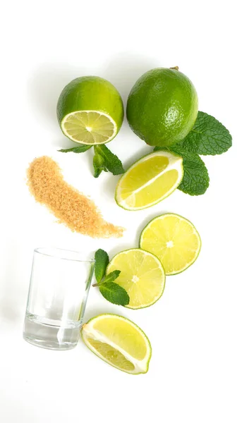 Mojito malzemeleri. Beyaz arka planda limon, nane ve kamış şekeri var. Tatlı şeker, nane yaprağı ve limon.