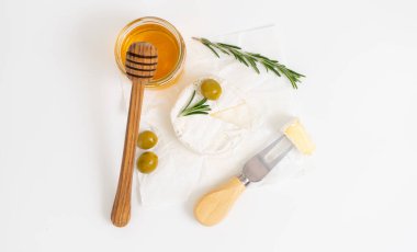 Bal ve biberiye filizli beyaz tabakta yuvarlak brie ya da camembert peyniri