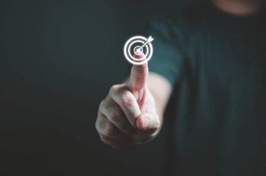 İş adamı, iş yatırımları için hedef ve başarı hedefleri belirlemek amacıyla hedef dart tahtasına dokunuyor. Ticari finans ve girişim kavramı.