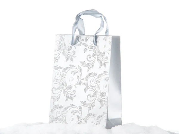 Zilveren boodschappentas op sneeuw agains witte achtergrond — Stockfoto