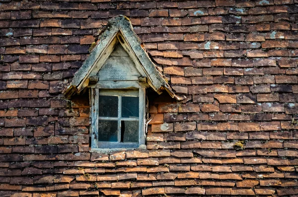 Starý oranžové cihlová střecha s rozbitým sklem způsob zbavení se okna — Stock fotografie