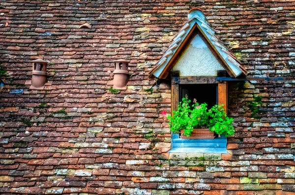 Antiguo techo de ladrillo naranja con ventana y flores — Foto de Stock