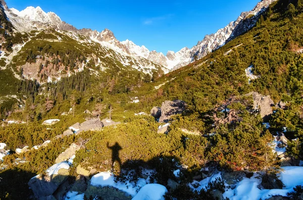 Winter mountains and shadow silhouette of a man — Stock Photo, Image