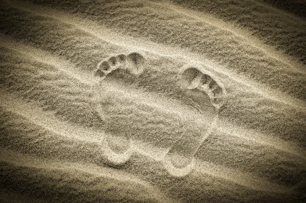 Deux empreintes de pas dans le sable sur la plage déserte — Photo