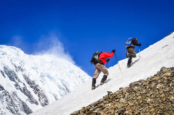 Two mountain trekkers on snow with peaks background — Stock Photo, Image