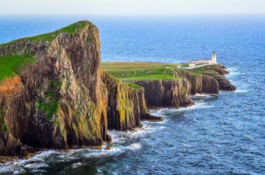 View of Neist Point lighthouse and rocky ocean coastline, Scotla clipart