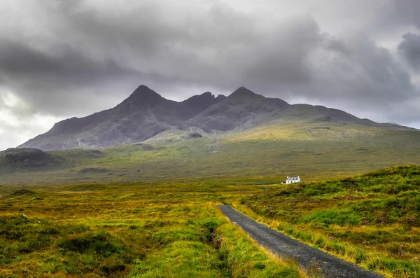 Cuillin Hills montanhas com casa solitária e estrada, Escócia — Fotografia de Stock