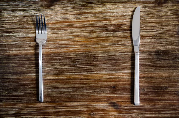 Nóż i widelec zestaw na drewnianym stołem — Zdjęcie stockowe