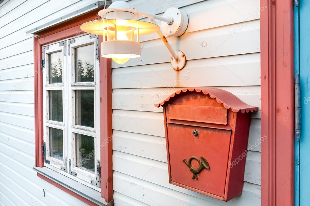 Mail box, window and lamp on a white wooden house