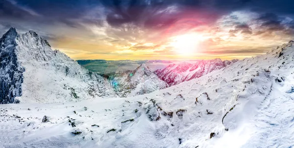 Panoramablick auf weiße Winterberge bei buntem Sonnenuntergang — Stockfoto
