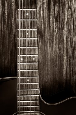 Detail of acoustic guitar in vintage style on wood background clipart