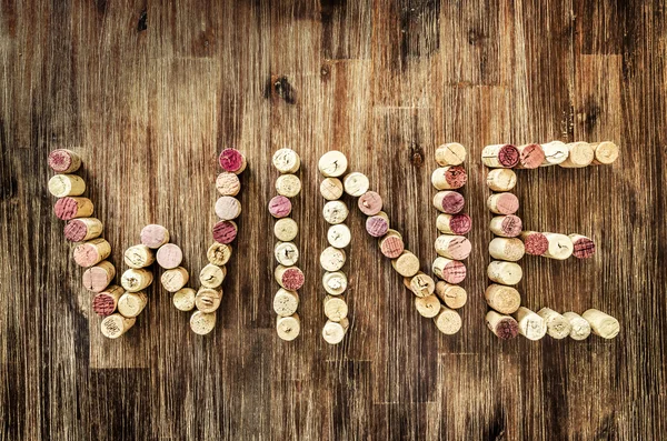 Assine o vinho feito de rolhas na mesa vintage de madeira — Fotografia de Stock